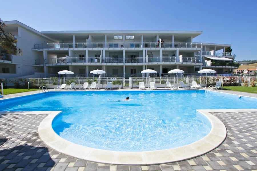 La piscina e la facciata del Residence Mykonos a Pineto